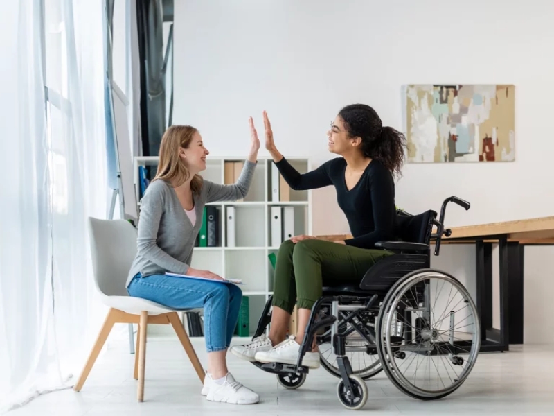 Women sharing high five during ndis home and living supports session.