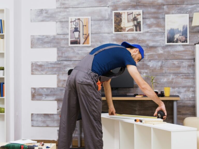 Worker measuring wood indoors for high quality home maintenance.